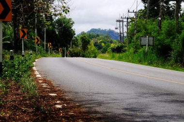Manzaralı yoldan yeşil ağaçlar ve gökyüzü vardır. Tayland seyahat.