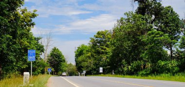 Dağ yolundan ağaçları ile. Manzaralı yoldan yeşil ağaçlar ve gökyüzü vardır. Tayland seyahat.
