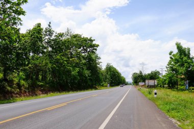 Manzaralı yoldan yeşil ağaçlar ve gökyüzü vardır. Tayland seyahat.