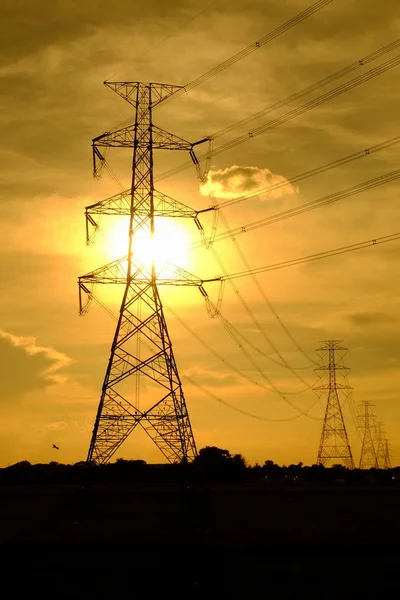 High-voltage transmission towers Send electricity from the power plant to the people. With the golden sky in the sunset