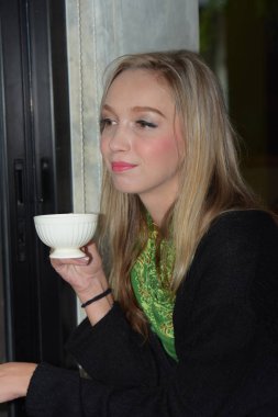 Güzel kız kafede kahve içiyor.