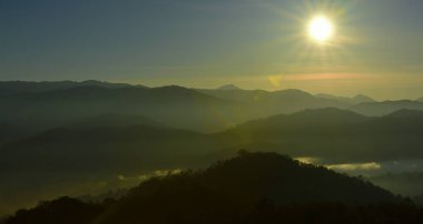 Tayland'da dağların üzerinde parlayan güneş