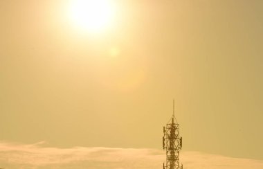 Gün batımı arka planında uzun elektrik kulesi