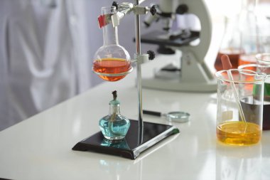 Cam test tüpleri ve mavi zemin üzerinde renkli sıvıyla moleküler yapısı olan mataralar.