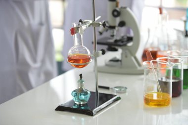 Cam test tüpleri ve mavi zemin üzerinde renkli sıvıyla moleküler yapısı olan mataralar.