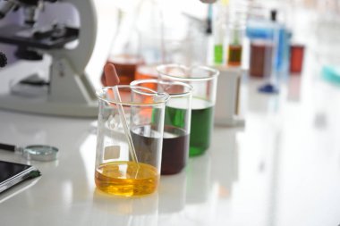 Cam test tüpleri ve mavi zemin üzerinde renkli sıvıyla moleküler yapısı olan mataralar.