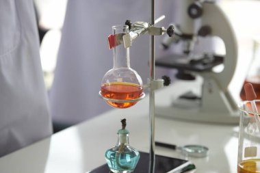 Cam test tüpleri ve mavi zemin üzerinde renkli sıvıyla moleküler yapısı olan mataralar.