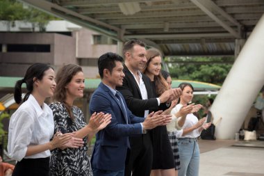 Şehirdeki iş adamları alkışlıyor.