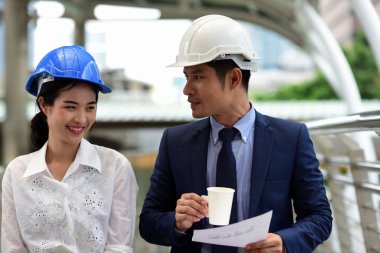 İki mimar inşaat alanında konuşuyor.