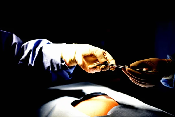 Medical Team Performing Surgical Operation in Modern Operating Room. Equipment and medical devices in hybrid operating room.scrub nurse preparing medical instruments for operation.