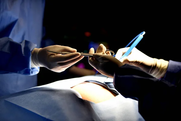 Medical Team Performing Surgical Operation in Modern Operating Room. Equipment and medical devices in hybrid operating room.scrub nurse preparing medical instruments for operation.