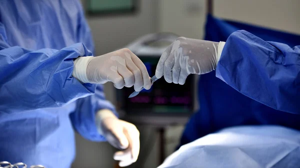 Medical Team Performing Surgical Operation in Modern Operating Room. Equipment and medical devices in hybrid operating room.scrub nurse preparing medical instruments for operation.