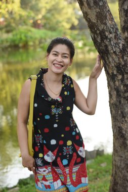 Genç Asyalı bir kadının portresi Çiçek parkında gündüz vakti renkli çiçeklerle poz veriyor  