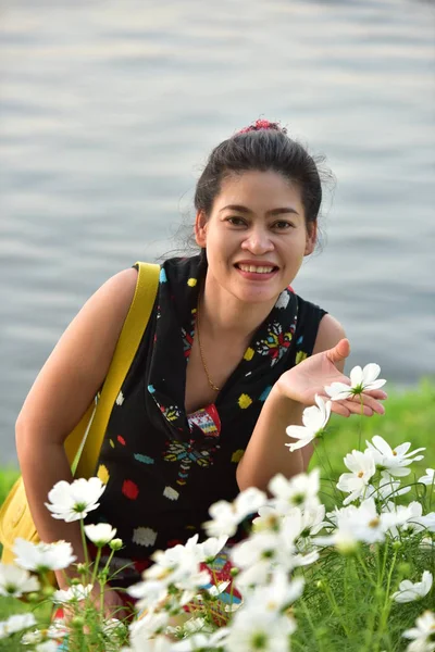 昼間は色とりどりの花を咲かせ花公園にポーズをとる若いアジア人女性の肖像 — ストック写真