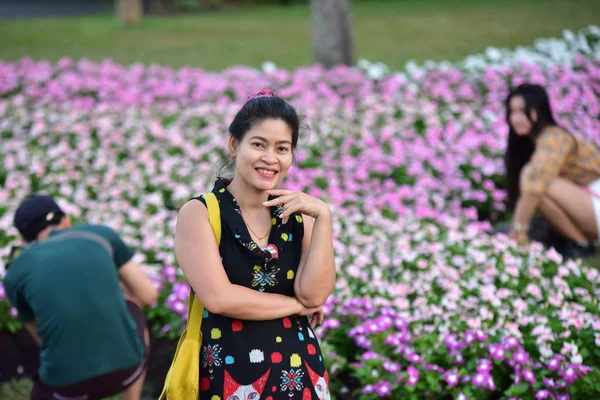 亚洲年轻女子的肖像 白天在花园里摆设着五彩缤纷的花朵 — 图库照片