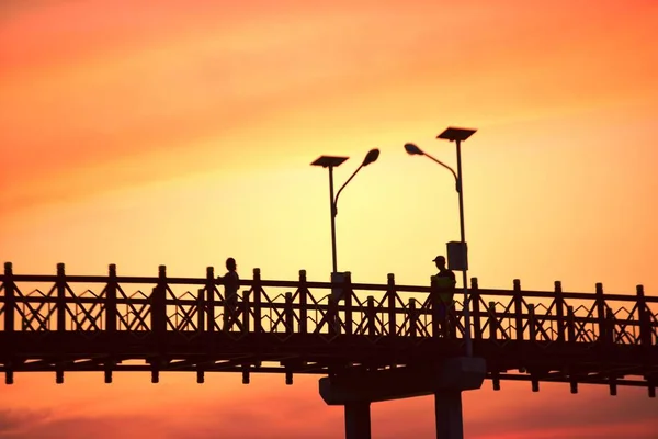 Menschen Gehen Bei Sonnenuntergang Auf Brücke — Stockfoto