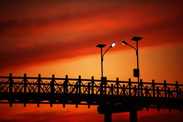 The silhouette of the steel bridge and the light after the sunset before dark