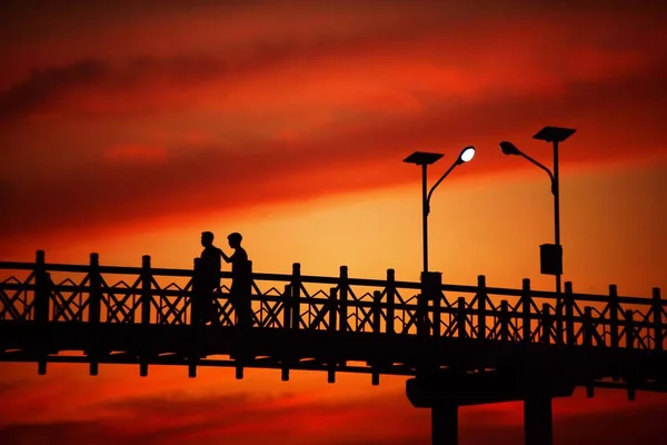 黄昏前钢桥的轮廓和日落后的灯光 — 图库照片