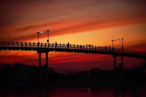 日落时在桥上行走的人 — 图库照片