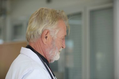 Steteskoplu ve üniformalı yaşlı bir doktor. 