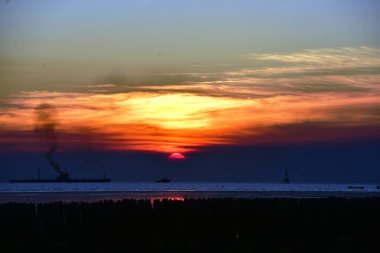 Gün batımı ve alacakaranlıktan önce denizin renkli gökyüzü