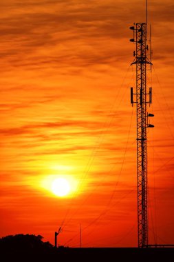 Güneşin batışı, şehir merkezindeki iş alanı günbatımı gökyüzü, kablosuz telefon direği ve sabahın erken saatlerinde turuncu-sarı gökyüzü.