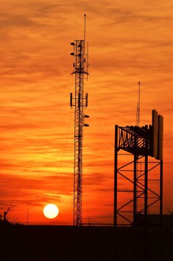 Güneşin batışı, şehir merkezindeki iş alanı günbatımı gökyüzü, kablosuz telefon direği ve sabahın erken saatlerinde turuncu-sarı gökyüzü.