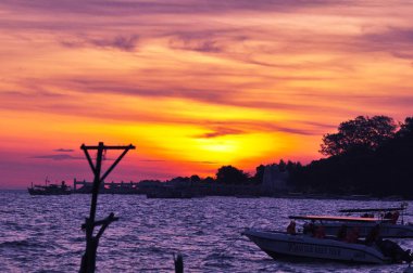 Güzel sarı gökyüzü ve güneş plajın, kumsalın ve güneş pansiyonlarının manzarası yükseliyor. Güzel sarı gökyüzü ve güneş