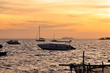 Güzel sarı gökyüzü ve güneş plajın, kumsalın ve güneş pansiyonlarının manzarası yükseliyor. Güzel sarı gökyüzü ve güneş