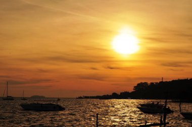 Güzel sarı gökyüzü ve güneş plajın, kumsalın ve güneş pansiyonlarının manzarası yükseliyor. Güzel sarı gökyüzü ve güneş