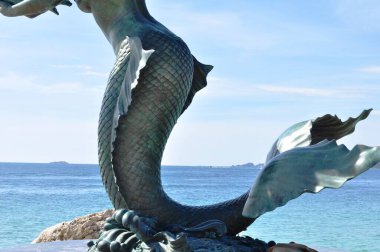 Deniz kıyısında çocuklu deniz kızı heykeli