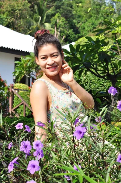 Bahçedeki Mor Çiçekli Asyalı Kadın — Stok fotoğraf