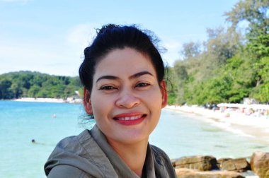 Deniz kıyısındaki Asyalı kadın