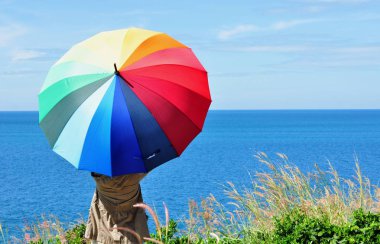 Koh Samet 'in sahil şeridine bakan tepede renkli şemsiyeli güzel kadınlar..