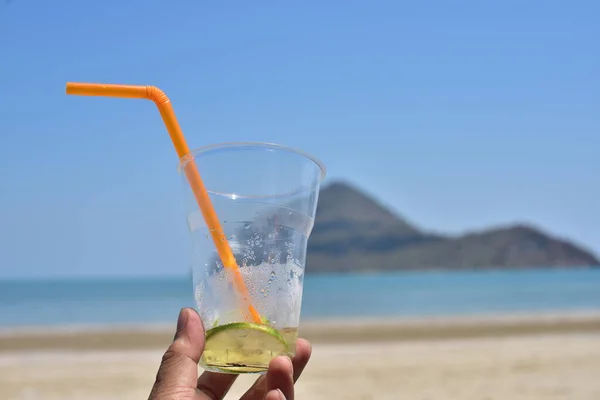 Persona Sosteniendo Vidrio Con Jugo Playa Del Mar —  Fotos de Stock