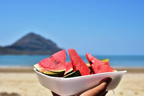 Person Holder Plade Med Vandmelon Stykker Havet Strand - Stock-foto