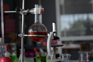 Bir bardak su ve pipetli laboratuvar bardağı. 