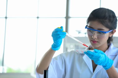 Bilimadamları bilim laboratuarlarında çalışıyor. Kovid19 için mikroskop araştırması yapan genç bir bilim adamı ve bilim adamının yakın çekimi..