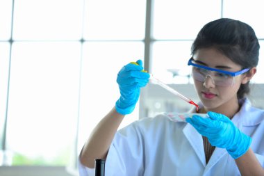 Genç kadın bilim adamları labradorda bilim deneyleri yapıyorlar. Laboratuvarda deney tüpü tutan bilim adamı, bir bilim adamının, bir mikroskopta araştırma yapan genç bir bilim adamının yakın plan fotoğrafı. Kovid19 için ilaç..