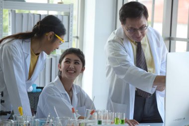 Bilimadamları bilim laboratuarlarında çalışıyor. Kovid19 için mikroskop araştırması yapan genç bir bilim adamı ve bilim adamının yakın çekimi..