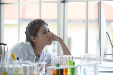 Laboratuvarda test tüpleriyle genç bir kadın.