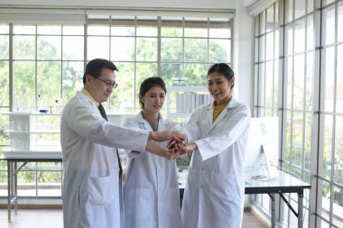 Asyalı doktor ve hemşire hastane koridorunda el sıkışıyor.