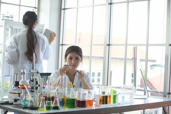 young woman scientist in laboratory working with test tubes
