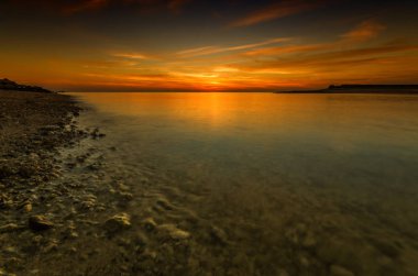 Denizde kayalık Plajı'nda canlı günbatımı