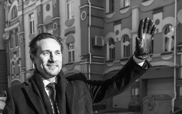 Businessman standing on the porch of the office with paper in hand, day, outdoor