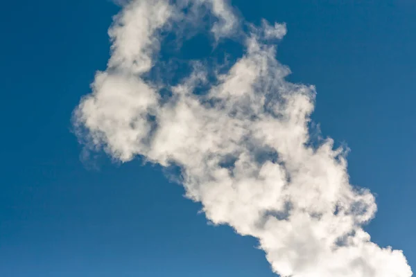 Mavi gökyüzüne karşı beyaz buhar ya da duman. Bulut ışığı.