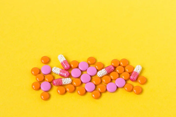 Parlak sarı arka planda çok renkli haplar. Hastalar için ilaç tedavisi. Sağlık için ilaç ve vitamin. Uzayı kopyala Kapat..