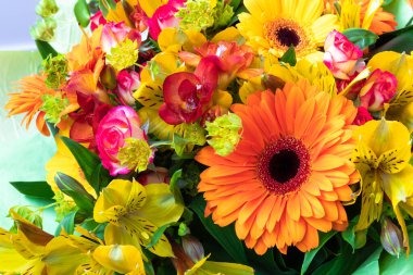 Bir buket çiçeğin içinde parlak turuncu gerbera. Tatil için güzel bir buket hediye. Kartpostal olarak çiçek açan bitkiler..