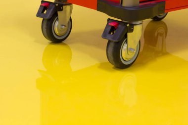Wheels of Drawer roller tool cabinet on the yellow epoxy floor clipart