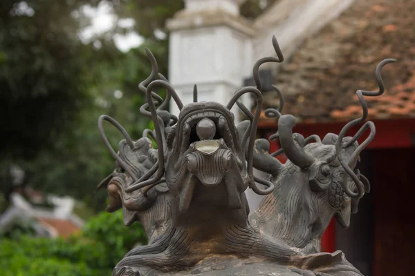 Three headed dragon made of bronze with glass ball in their mouth on the top of the antique incense burner at Temple of Literature (Original built in 1070) in Hanoi, Vietnam